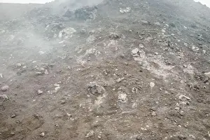 Earthquake Prints: Top of crater Mount Etna volcano, frozen cold lava smokes, thick clouds