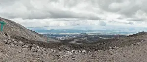 Top of crater Mount Etna volcano, frozen cold lava smokes, thick clouds