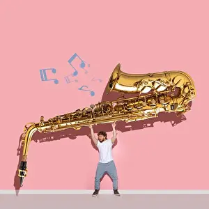 Cyberpunk Prints: Creative design. Young man holding giant golden trumpet isolated over pink background