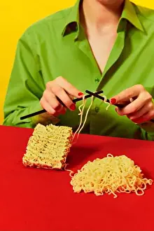 Tasting Prints: Creative image with woman knitting instant noodles on blue table on vivid red tablecloth over yellow background