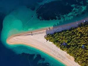 Croatia, Brac island, Bol. Panoramic aerial view of the Zlatni Rat sandy beach and sea from made with drone