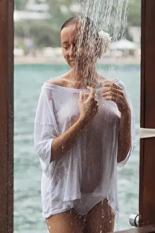 Rest Prints: Crop young lady in wet white blouse embracing herself trying to avoid splash of clean water