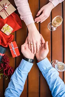 cropped image of boyfriend holding girlfriends hand with wedding ring