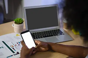 Texting Prints: Cropped image of man using phone at desk in creative office