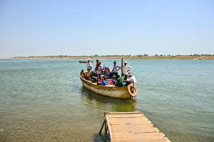Gujarat Prints: A crowded rowboat leaving the dock on Narmada river at Nareshwar, Vadodara, Gujarat, India