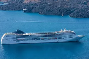Cruise ship near Santorini, summer travel tourism boats in blue sea bay, cliffs of Santorini volcano island. Famous travel destination