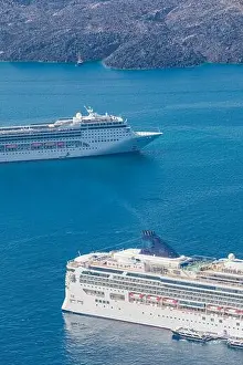 Cruise ship near Santorini, summer travel tourism boats in blue sea bay, cliffs of Santorini volcano island. Famous travel destination