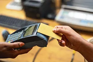 25 29 Years Prints: Customer making a purchase using a credit card on a point of sale terminal