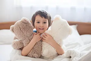 Sleepy Prints: Cute boy with teddy bears, lying in bed, looking at camera, smiling