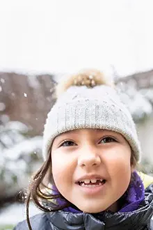 Eyes Closed Prints: Cute girl with eyes closed sticking out tongue during winter