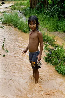Karen Prints: A cute Karen boy plays in a small stream