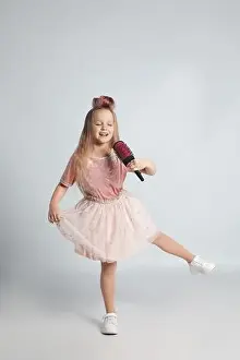 Hairbrush Prints: Cute little girl with hairbrush singing on light grey background