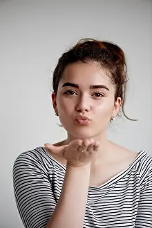 Cute lovely young woman standing and sending kiss over white background.Flying Kiss, Woman in Love