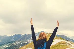 Mountain View Prints: Cute young blond woman stands with her arms raised