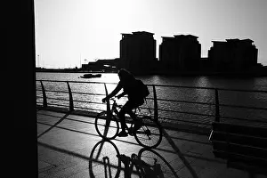 Early Morning Prints: Cyclist commute on an early winter morning Swansea marina in silhouette