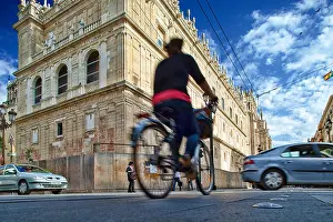 Sevilla Prints: Cyclist in front of Sagrario Church, Constitution Avenue, Seville, Spain