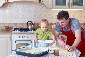 Stove Prints: Dad teaches the small child to preparing baking cookies or pastries together