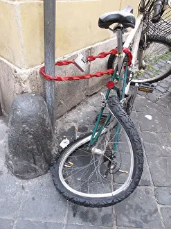 Bent Prints: damaged bike locked to pole in street road