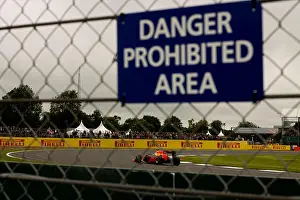 Prohibited Prints: Daniel Ricciardo at Luffield corner at Silverstone Grand Prix circuit behind a spectator fence with a warning sign