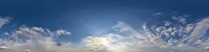 Dark blue sunset sky panorama with golden Cumulus clouds
