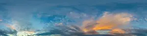 Dark blue sunset sky panorama with golden Cumulus clouds