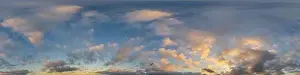 Dark blue sunset sky panorama with golden Cumulus clouds