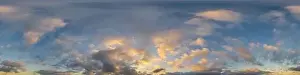 Dark blue sunset sky panorama with golden Cumulus clouds