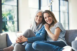 Mid Adults Prints: Daughter holding mother in her arms, sitting on couch