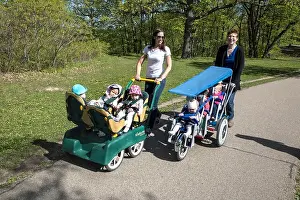 Daycare woman taking a walk with toddlers in multi fit strollers. North Mississippi River Boulevard. St Paul Minnesota MN USA