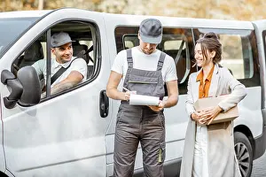 Delivering Prints: Delivery company employees in uniform delivering goods to a client by cargo van vehicle