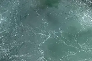 Seafoam Prints: Detailed close-up of a turbulent green ocean water surface