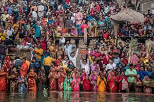 Offering Prints: Devotees make offerings and pray in the Ganges during Chhath Puja in Varanasi, India