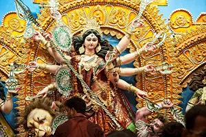 Worshiping Prints: Devotees worshiping the Goddess Durga at nagar bazaar durga puja pandal kolkata west bengal india
