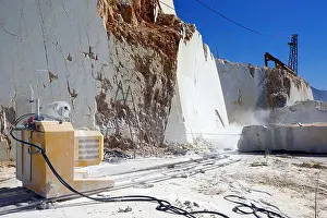 Quarry Prints: Diamond wire saw machine cutting marble blocks in the Carrara marble quarry