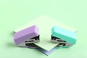 Fastener Prints: Different small staplers with sticky notes on green background
