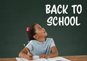 Schoolbag Prints: Digital composite of Student girl at table looking up against green blackboard with back to school text