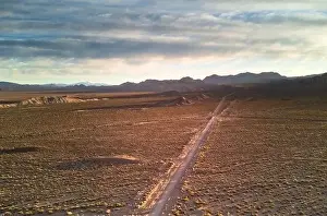 Dirt road across the desert steppes by the Andes mountains near Uspallata, Argentina