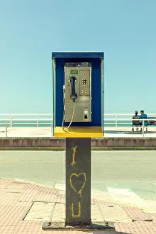 Non Urban Prints: Dirty and disused phone booth with romantic graffiti and a couple in the background