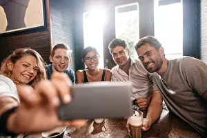 Photographing Prints: Diverse group of friends taking selfie on smart phone