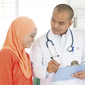 Malaysian Prints: Doctor discussing treatment options with patient. Southeast Asian Muslim people