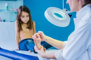 Barefooted Prints: Doctor examining girl's foot