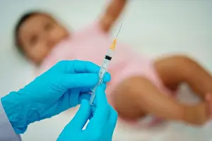 Vaccine Prints: doctor holding syringe and preparing vaccine giving injection to infant baby
