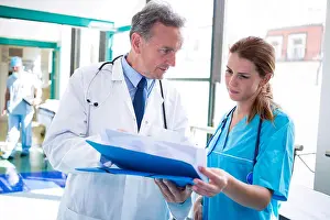 Coworker Prints: Doctor and nurse checking medical report