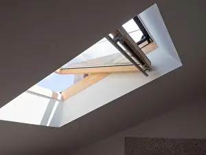 Loft Prints: dormer wooden window in the white sloping ceiling overlooking the blue sky