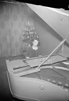 Entertain Prints: Dorothea Aspinall performs on a grand piano for American troops in a London flat during a Christmas celebration