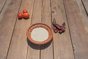 Gourmet Food Prints: dough for Mexican tortillas in clay plate on table with chili peppers and tomatoes