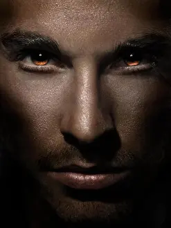 Devil Prints: Dramatic closeup of man face with fierce eyes burning with red
