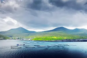 Dramatic morning view on Sandavagur village and fish farm on Vagar island, Faroe Islands, Denmark. Landscape photography