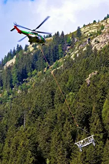 Helicopter Prints: A dramatic picture of a helicopter carrying metal parts for the construction of a ski lift in Chamonix in the French