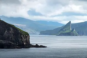 Dramatic view on Drangarnir and Tindholmur sea stacks in Atlantic ocean from Mykines island, Faroe Islands. Landscape photography